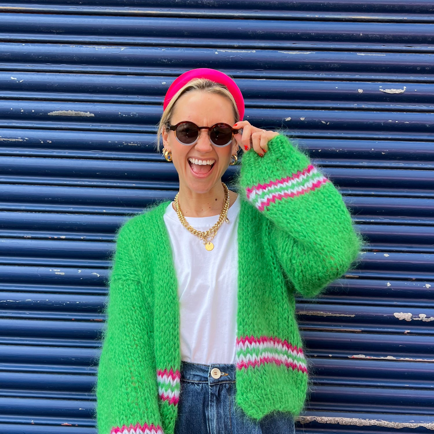 good manners style pink headband on founder looking forward and smiling while touching sunglasses