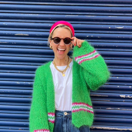 good manners style pink headband on founder looking forward and smiling while touching sunglasses